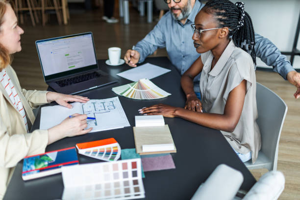 Interior designer meeting with clients and discussing new flat project, choosing colours for wall, materials for furniture